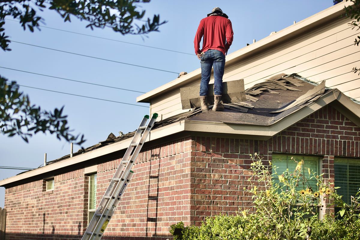 Jopco roofer tearing off old shingles on a North Texas home