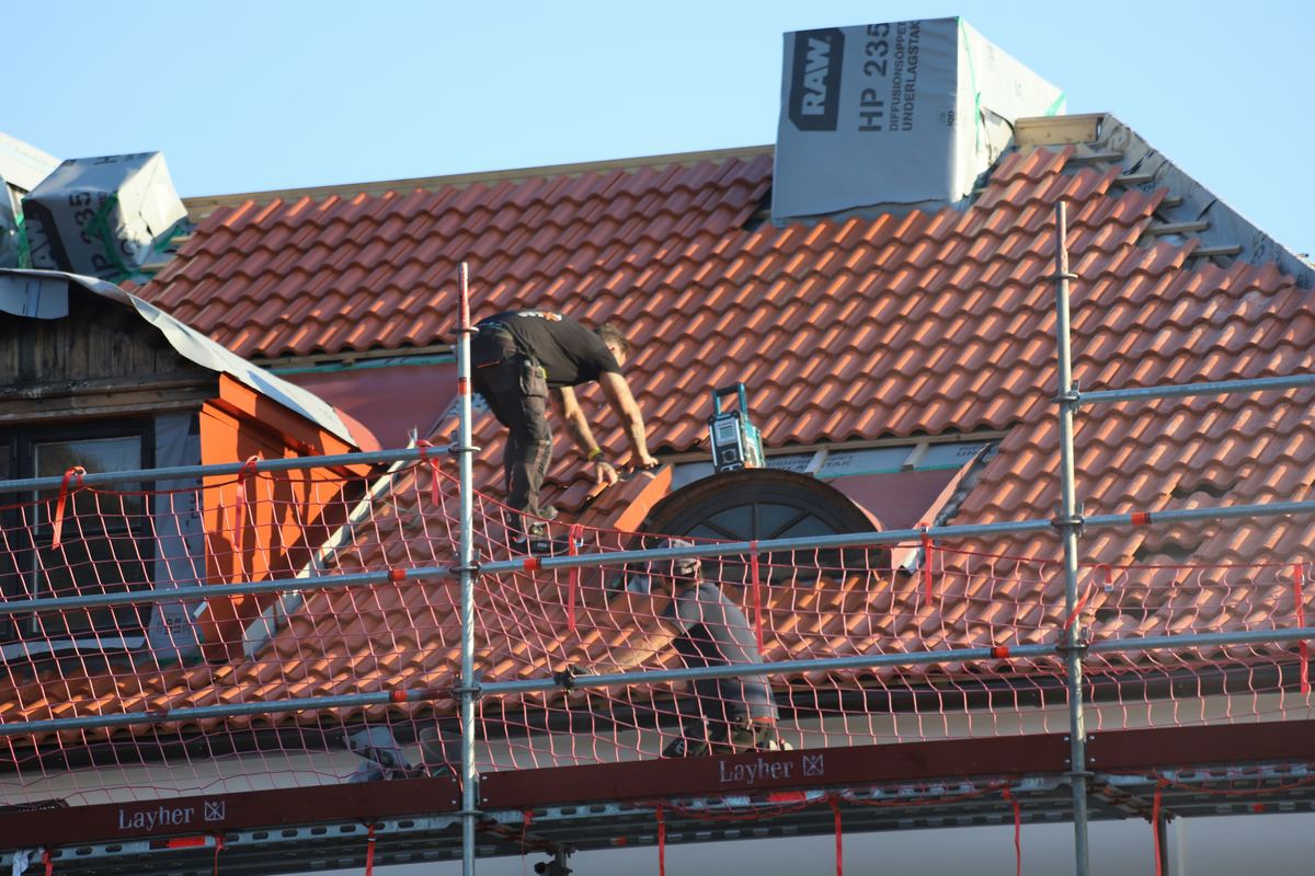Jopco crew installing tile roofing on a home